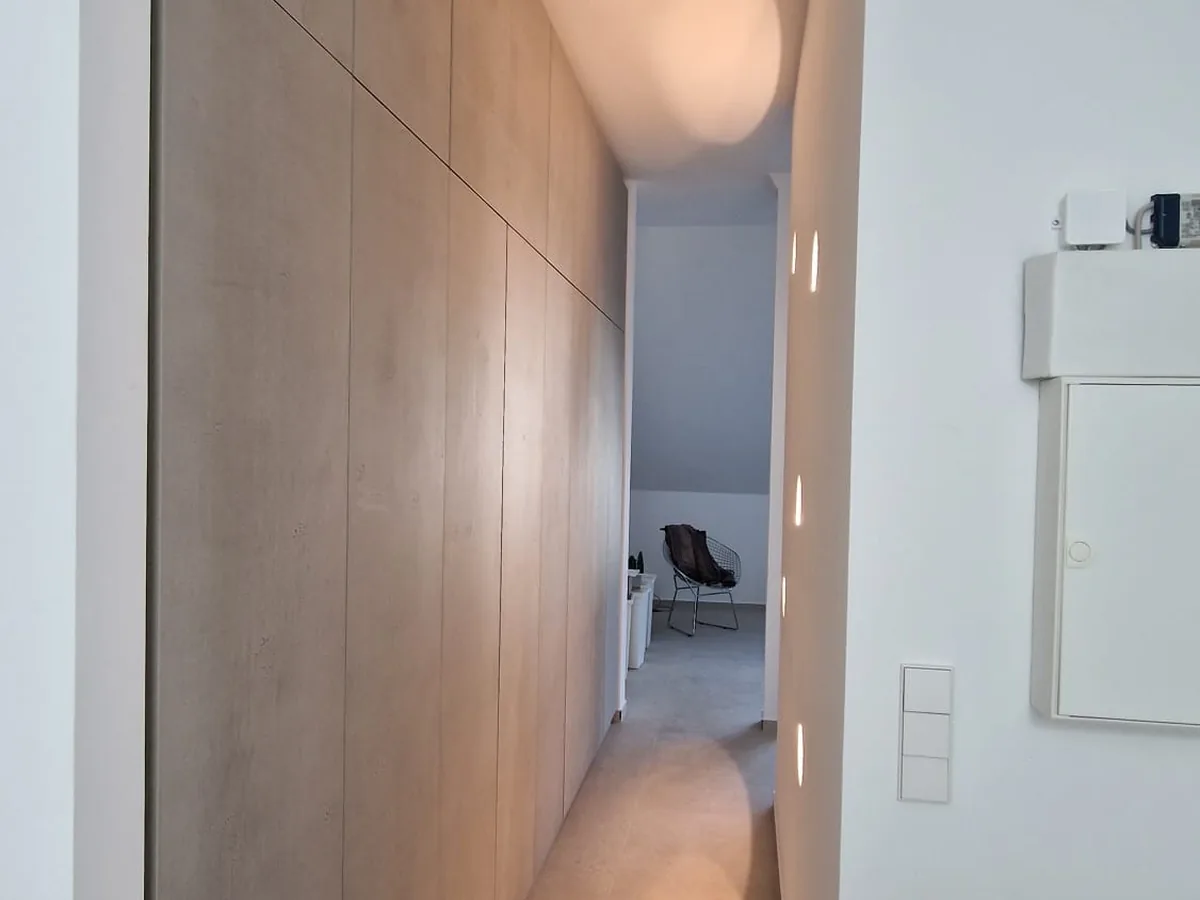 Eingebaute Schrankwand in heller Holzoptik, vom Boden bis zur Decke